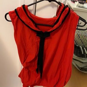 Red sleeveless top with black tie in front